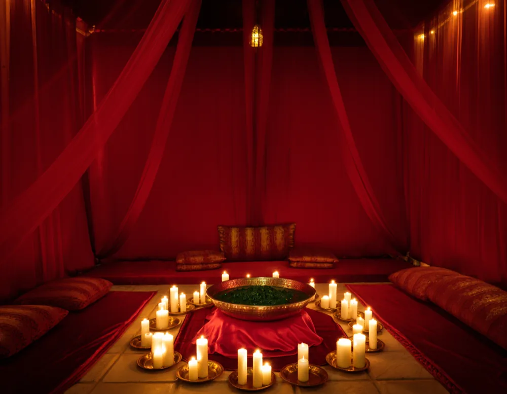 The henna lounge in red and gold, candles and copper trays around the central platform