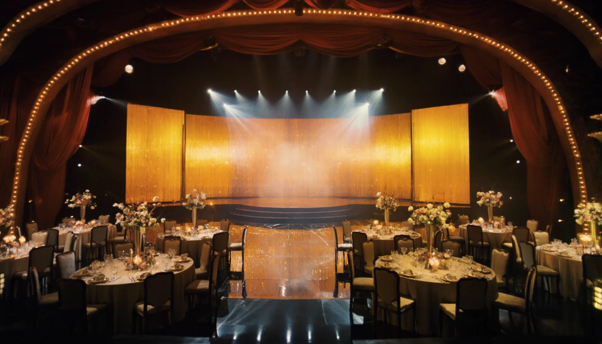The main hall dressed for a wedding, crimson drapes and a glowing LED stage wall